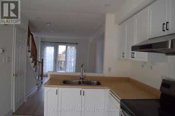 Pickering (Town Centre) townhouse for rent - A kitchen with white cabinets and a wooden countertop.