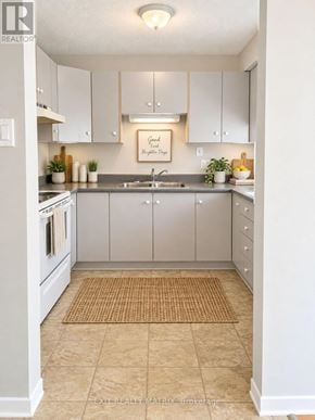 Casselman multi-family for rent - A kitchen with white cabinets and a beige rug on the floor.