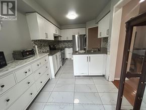 Brampton (Sandringham-Wellington) apartment for rent - A kitchen with white cabinets and a marble floor.