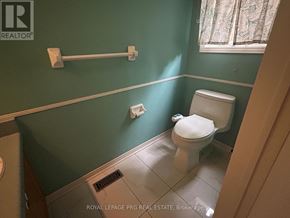 Brampton (Sandringham-Wellington) apartment for rent - A white toilet in a small bathroom with green walls.