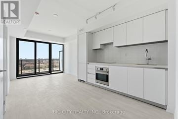 Toronto (Thorncliffe Park) condo for rent - A modern kitchen with white cabinets and a large window.