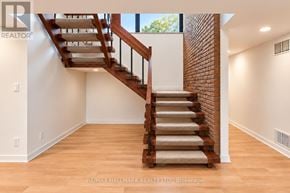 Toronto (Bridle Path-Sunnybrook-York Mills) apartment for rent - A wooden staircase with a beige carpeted runner leads up to a bright room with white walls.
