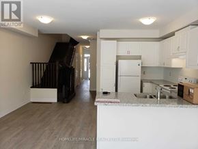 Caledon townhouse for rent - A kitchen area with a sink, refrigerator, and cabinets.