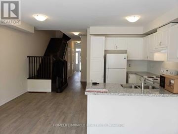 Caledon townhouse for rent - A kitchen area with a sink, refrigerator, and cabinets.
