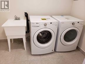 Caledon townhouse for rent - Two front loading washing machines in a small laundry room.