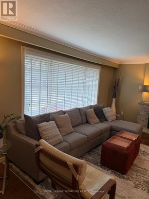 Oakville (Wo West) apartment for rent - A living room with a grey couch, a chair, and a small table.