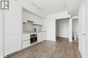 Toronto (Leaside) condo for rent - A white kitchen with a stove top oven and a refrigerator.