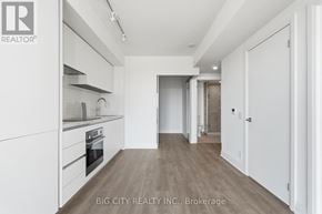 Toronto (Leaside) condo for rent - A spacious kitchen with white cabinets and a wooden floor.