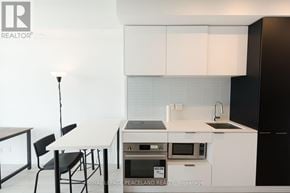 Toronto (Yonge-Eglinton) condo for rent - A kitchen with white cabinets and black appliances.