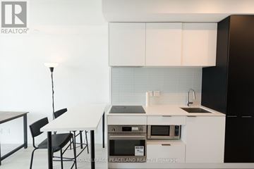 Toronto (Yonge-Eglinton) condo for rent - A kitchen with white cabinets and black appliances.