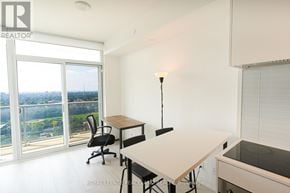 Toronto (Yonge-Eglinton) condo for rent - A room with a desk and chair in front of a window with a view of the city.
