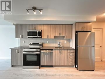 Pickering (Bay Ridges) condo for rent - A modern kitchen with stainless steel appliances and wooden cabinets.