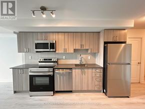 Pickering (Bay Ridges) condo for rent - A modern kitchen with a refrigerator, oven, and microwave.