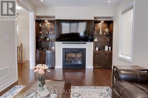 Brampton (Northwest Brampton) apartment for rent - A living room with a fireplace and a vase of flowers on the coffee table.
