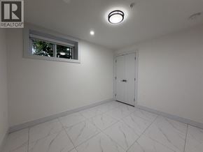Vancouver apartment for rent - A white tiled room with a window and a door.