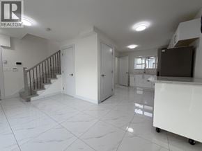 Vancouver apartment for rent - A spacious kitchen and living room with white tiled floors and a staircase with a metal railing.