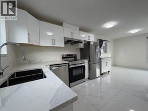 Vancouver apartment for rent - A modern kitchen with white cabinets and stainless steel appliances.