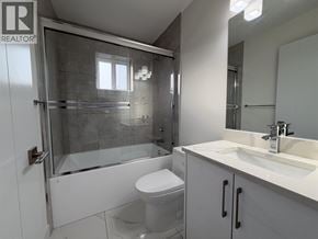 Vancouver apartment for rent - A white bathroom with a glass shower stall and a toilet.