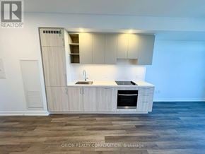 Vaughan (Vaughan Corporate Centre) condo for rent - A modern kitchen with wooden floors and cabinets.