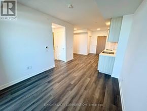 Vaughan (Vaughan Corporate Centre) condo for rent - A spacious room with wood flooring and white walls.