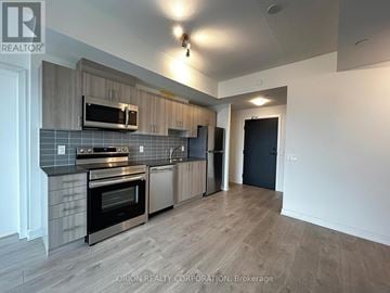 Pickering (Bay Ridges) condo for rent - A kitchen with a stove top oven and microwave above it.