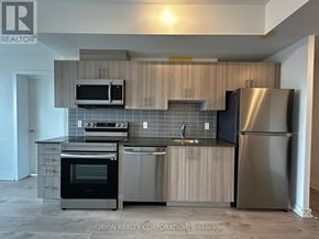 Pickering (Bay Ridges) condo for rent - A kitchen with a stainless steel refrigerator, microwave, oven, and sink.