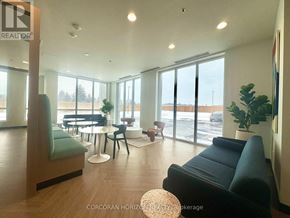 Kitchener condo for rent - A living room with a black couch and a wooden floor.