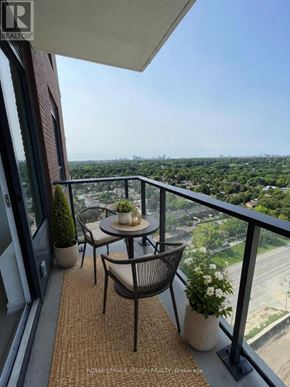 Toronto (Humber Heights) condo for rent - A balcony with a table and chairs overlooking a cityscape.