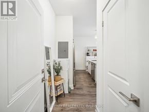 Richmond Hill (Oak Ridges) townhouse for rent - A hallway with a door on the left and a fridge on the right.