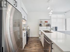 Richmond Hill (Oak Ridges) townhouse for rent - A modern kitchen with a stainless steel refrigerator and white countertops.