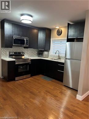 St. Catharines apartment for rent - A modern kitchen with dark wood cabinets and a white refrigerator.