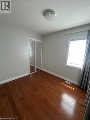 St. Catharines apartment for rent - A room with a wooden floor and a window with curtains.
