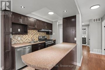 Russell condo for rent - A kitchen with dark wood cabinets and a checkered backsplash.