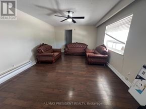 Caledon (Bolton North) apartment for rent - A living room with a ceiling fan and brown leather furniture.