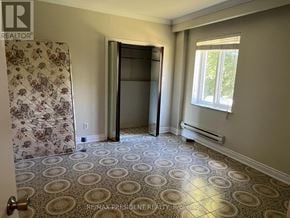 Caledon (Bolton North) apartment for rent - A room with a patterned floor and a door leading to another room.