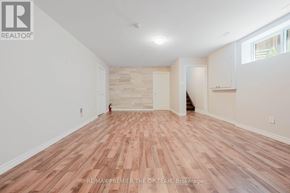 Vaughan (West Woodbridge) apartment for rent - A room with wooden flooring and white walls, with a logo that reads RE/MAX PREMIER THE OP TEAM, Brokerage.