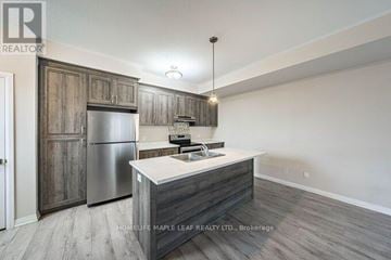 Kitchener townhouse for rent - A kitchen with a wooden cabinet and a stainless steel refrigerator.