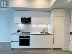 Toronto (Annex) condo for rent - A modern kitchen with white cabinets and appliances.