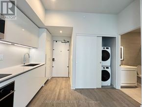 Toronto (Annex) condo for rent - A modern kitchen with white cabinets and a black countertop.