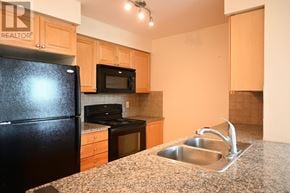 Toronto (Islington-City Centre West) condo for rent - A kitchen with a black refrigerator, microwave, and stove.