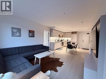 Port Moody apartment for rent - A living room with a grey couch and a white table.