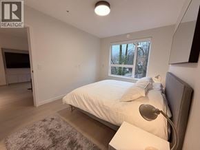 Port Moody apartment for rent - A bedroom with a bed, a window, and a rug.