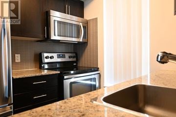 Toronto (Markland Wood) condo for rent - A kitchen with a stove top oven and microwave above it.