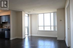 Toronto (Markland Wood) condo for rent - A spacious room with a kitchen area to the left and a large window with blinds on the right.