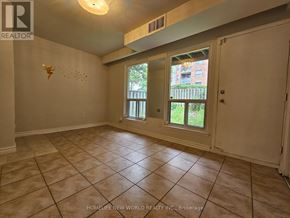 Toronto (Hillcrest Village) townhouse for rent - A room with tile flooring and a window overlooking a backyard.
