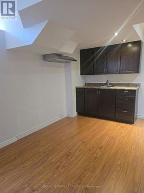 Mississauga (Meadowvale Village) apartment for rent - A kitchen with wooden floors and dark brown cabinets.