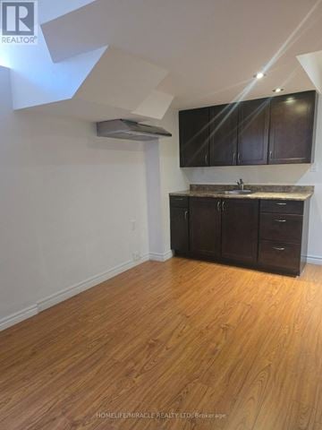 Mississauga (Meadowvale Village) apartment for rent - A kitchen with wooden floors and dark brown cabinets.