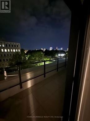 London East (East K) condo for rent - A balcony overlooks a city skyline at night.