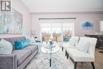 Niagara Falls (Forestview) apartment for rent - A living room with a grey couch, a glass table, and a painting on the wall.