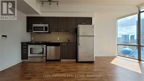 Toronto (Bay Street Corridor) condo for rent - A kitchen with a refrigerator, oven, and microwave.